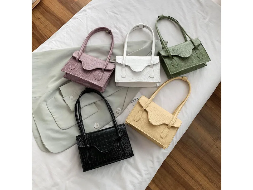 Five shoulder bags in different colors arranged on a white surface.