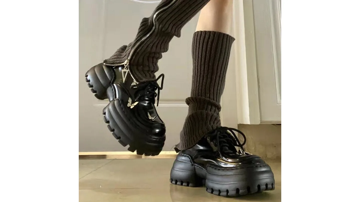 Black platform oxford shoes with butterfly accents styled with dark brown leg warmers.