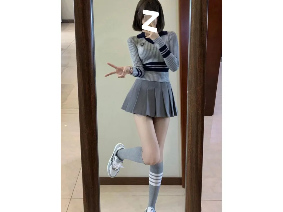 Model posing in the full outfit, showing the fit of the pleated skirt.