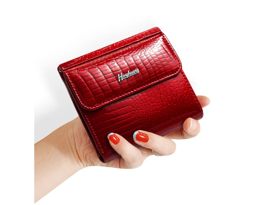 Red crocodile pattern leather wallet held in a hand