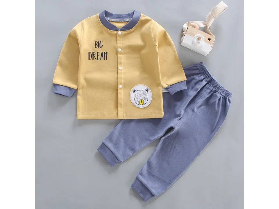 Yellow long-sleeve baby pajama top with 'BIG DREAM' text and a bear patch, paired with blue pants.