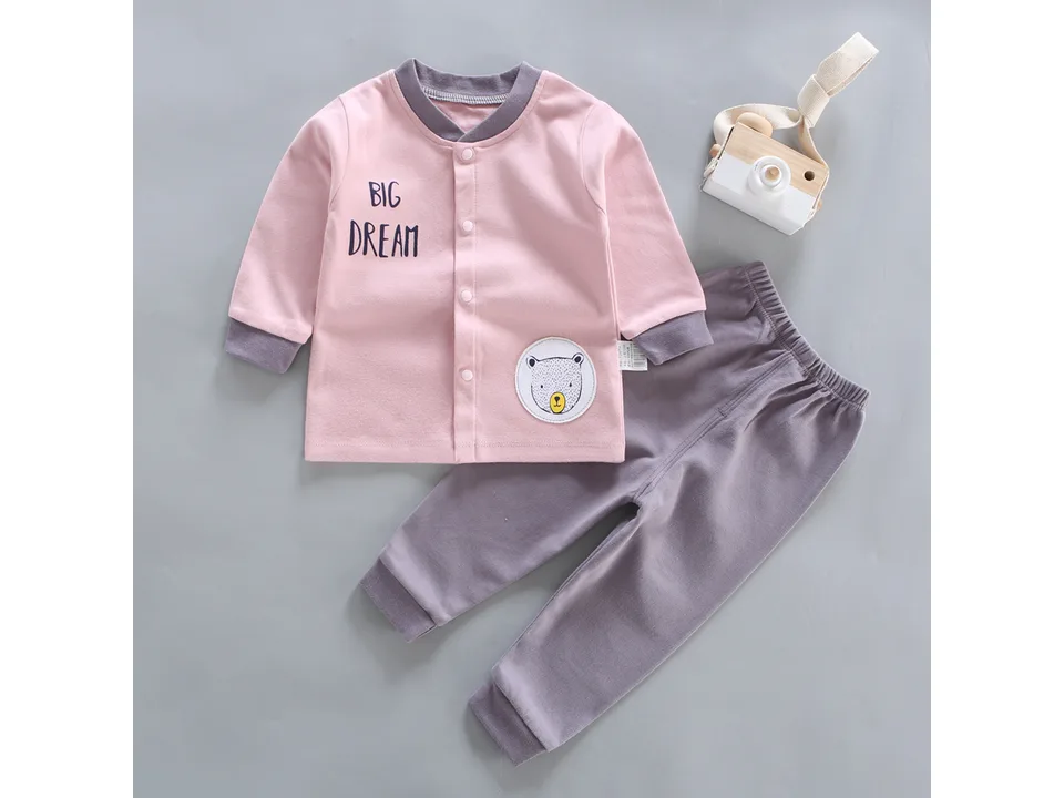 Pink long-sleeve baby pajama top with 'BIG DREAM' text and a bear patch, paired with grey pants.