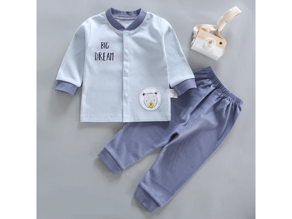 Light blue long-sleeve baby pajama top with 'BIG DREAM' text and a bear patch, paired with blue pants.