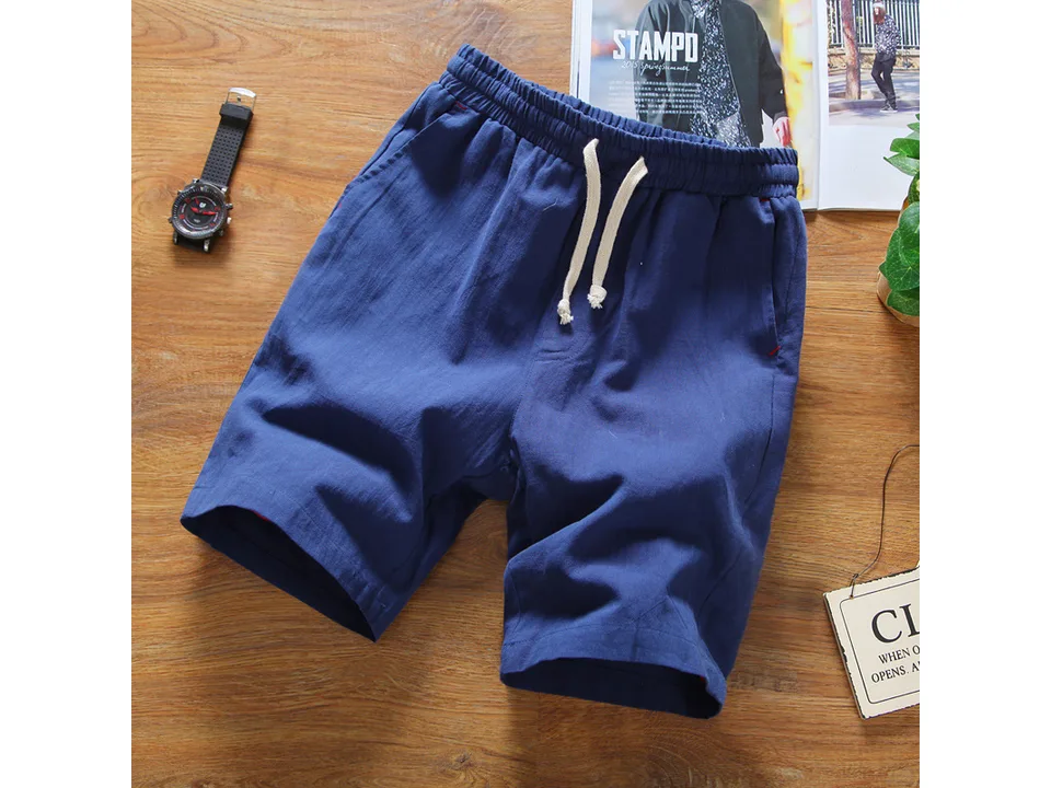 Blue casual linen shorts with drawstring waistband laid flat on a wooden surface.