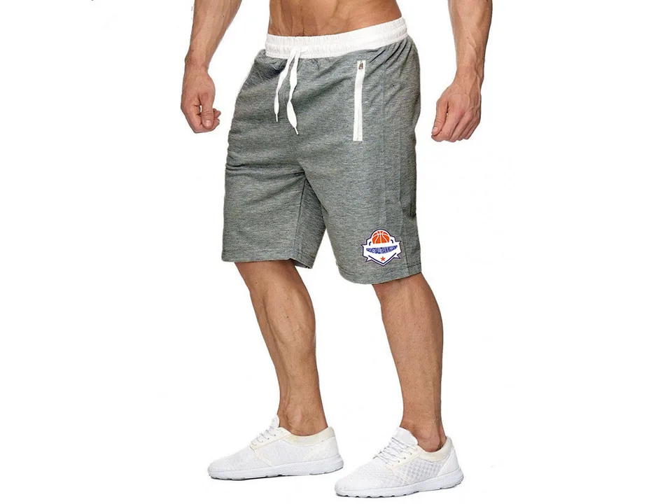 A man wearing grey athletic basketball shorts with a white drawstring waist and zipper pockets.