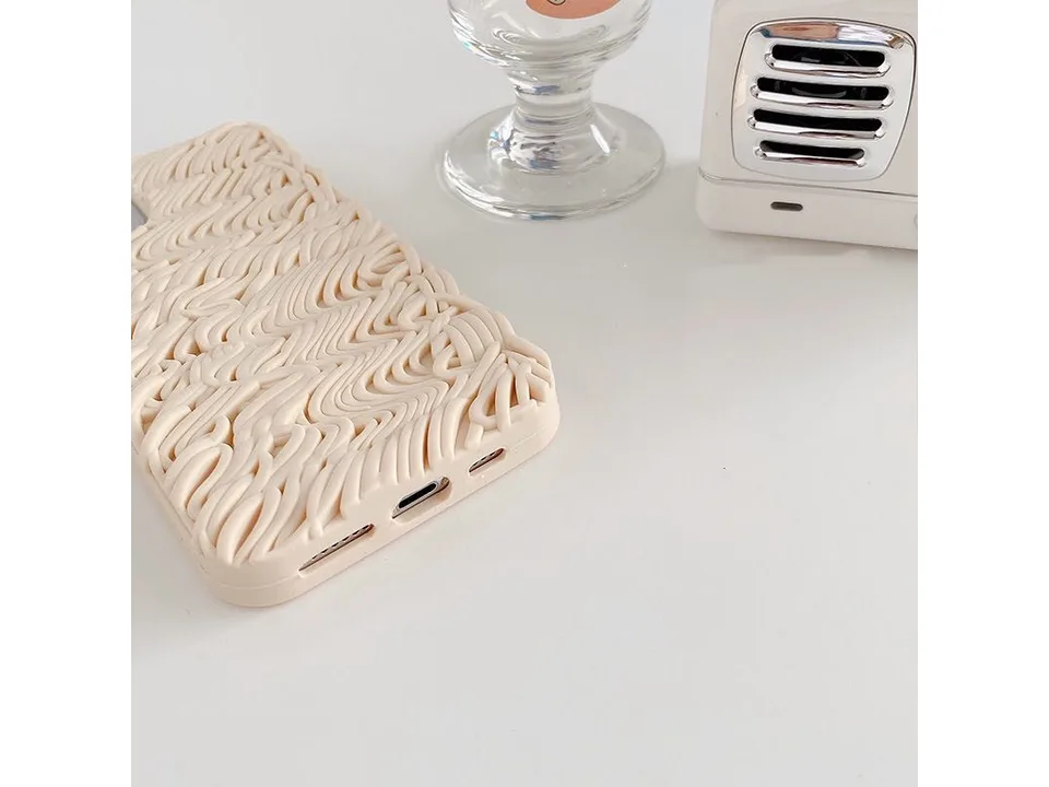 Close-up of the bottom edge of the noodle-textured phone case showing port cutouts.