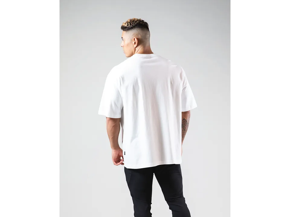 A man seen from the back wearing an oversized white t-shirt.