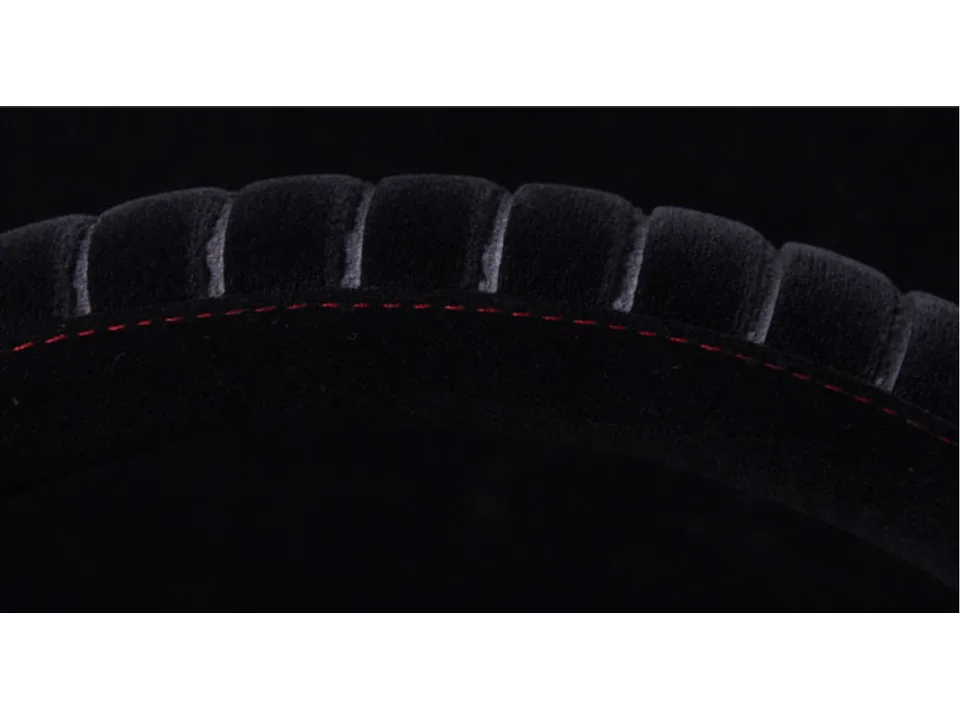 Close-up of the black plush steering wheel cover with red stitching detail.