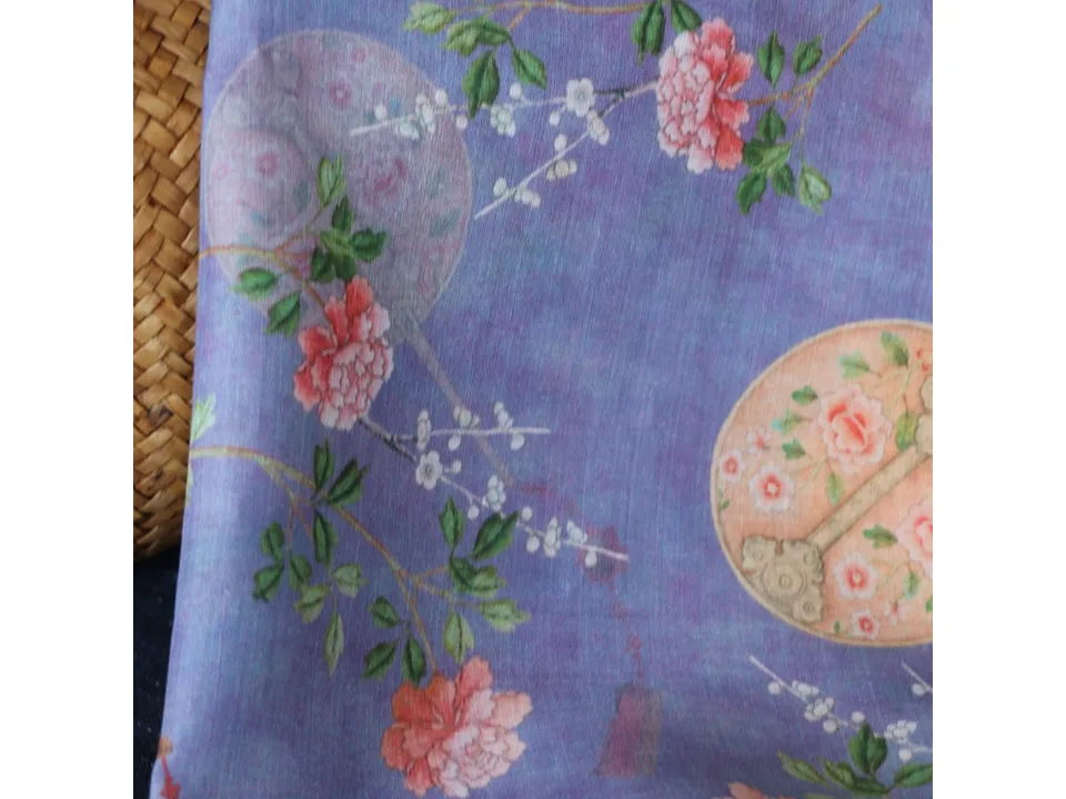 Detailed view of the floral and fan pattern on purple ramie fabric.