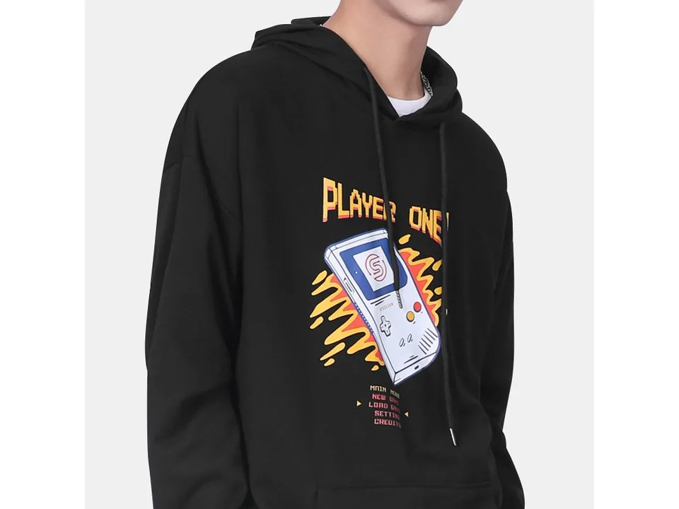 A person wearing the black hooded sweatshirt with a retro gaming console graphic.