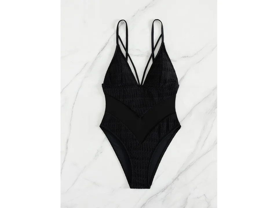 Front view of the black one-piece swimsuit with mesh detail on a marble background.