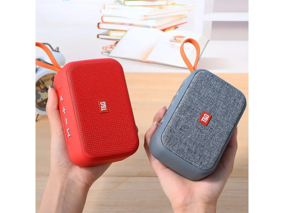 Two portable speakers, one red and one grey, being held in hands.