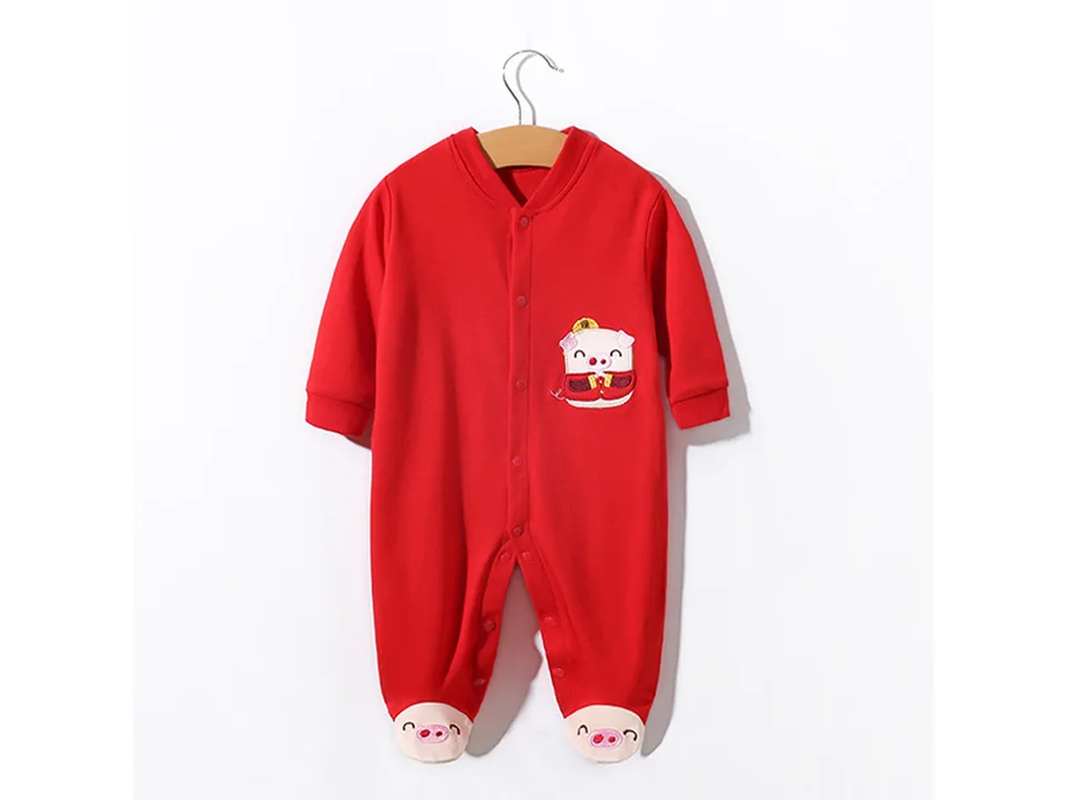 Red baby romper with a pig design hanging on a wooden hanger.