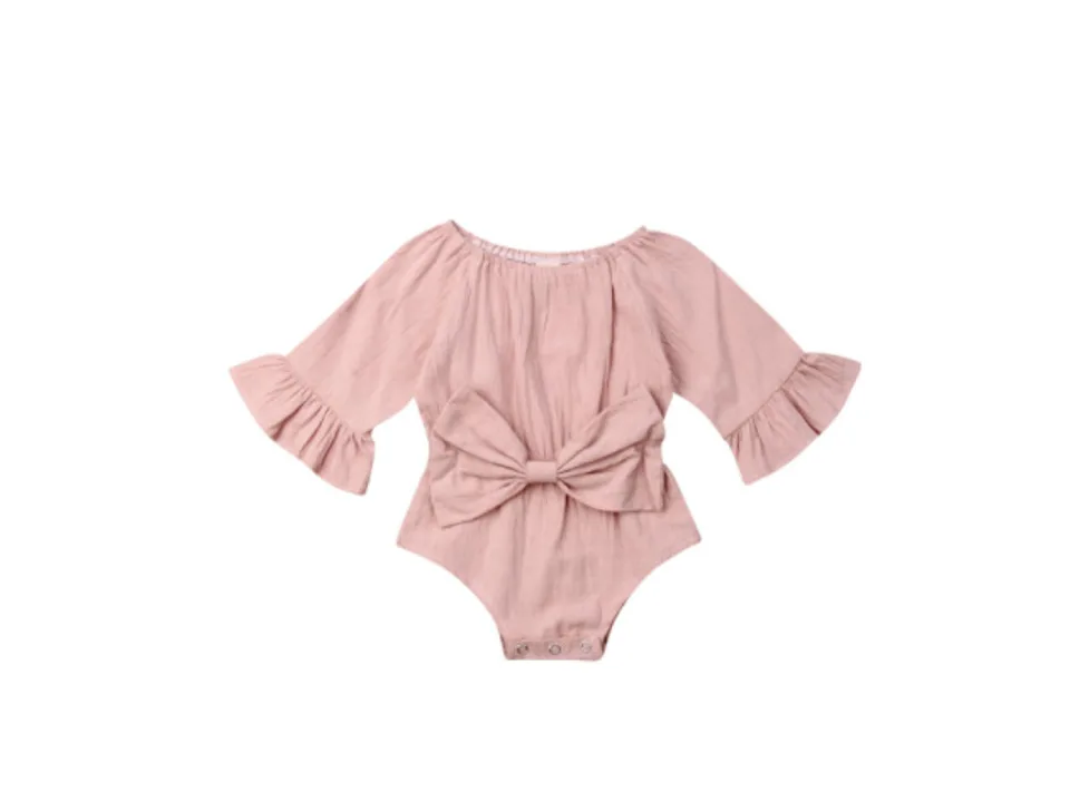 A pink long-sleeve baby bodysuit with a large bow on the front.