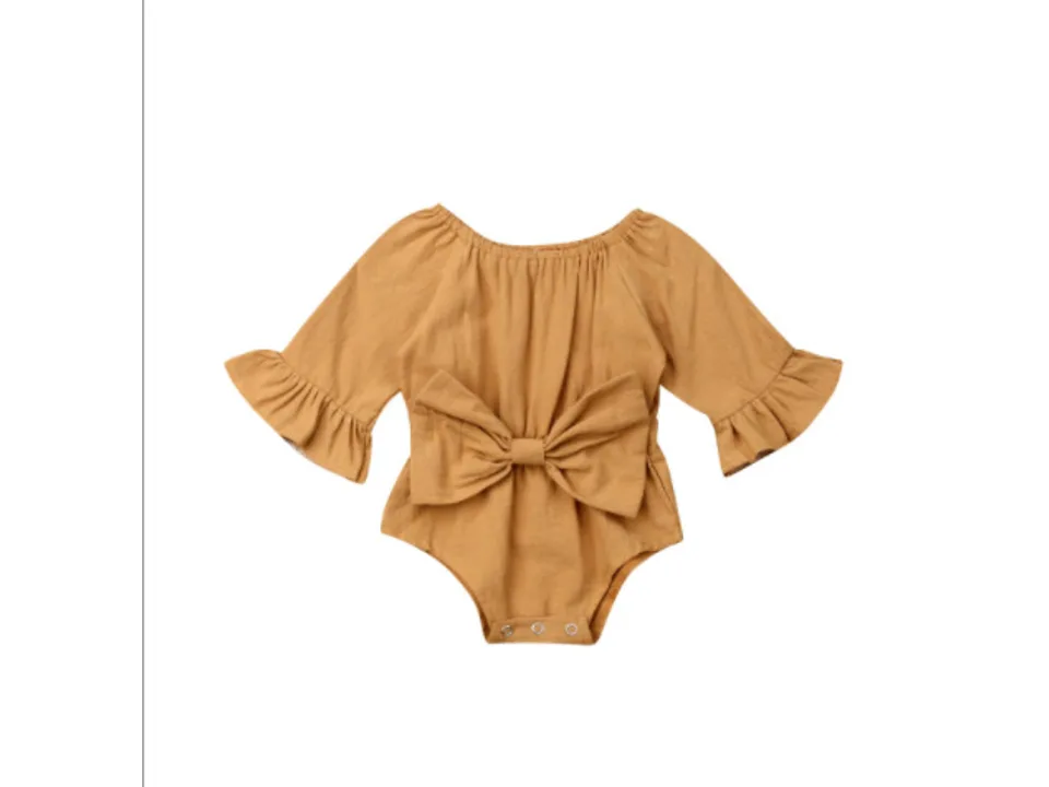 A tan long-sleeve baby bodysuit with a large bow on the front.