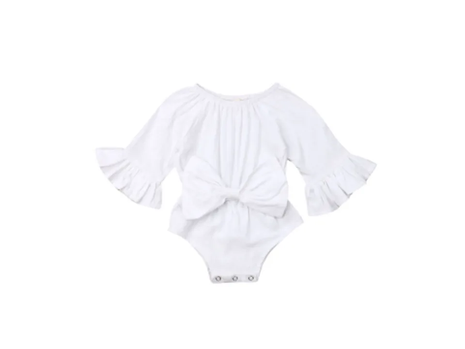 A white long-sleeve baby bodysuit with a large bow on the front.