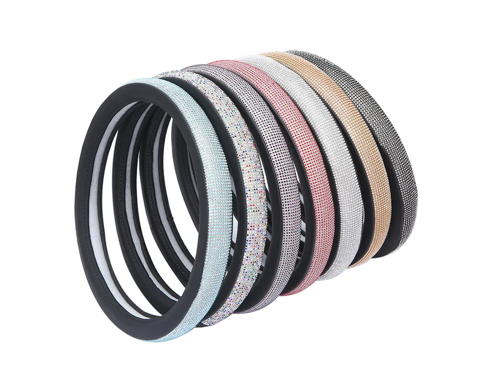 A collection of rhinestone steering wheel covers in various colors stacked together.
