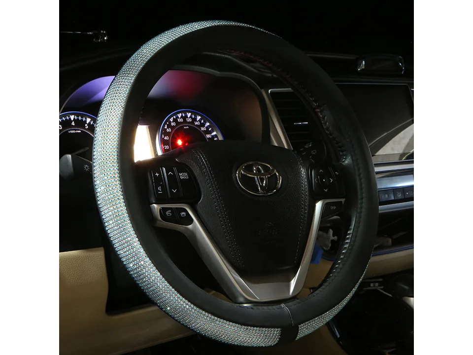 A blue rhinestone steering wheel cover installed on a car steering wheel.