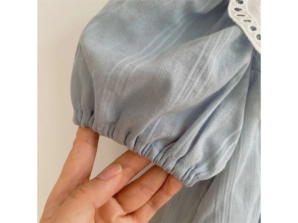Close-up of the gathered sleeve cuff on the light blue dress.