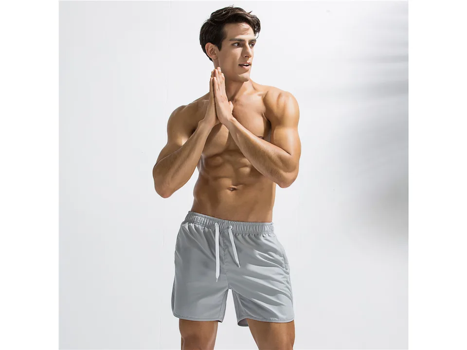 A man wearing grey quick-dry board shorts with a white drawstring.