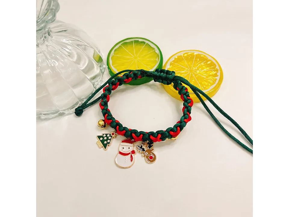 A single braided Christmas pet collar with snowman and reindeer charms next to lime slices.