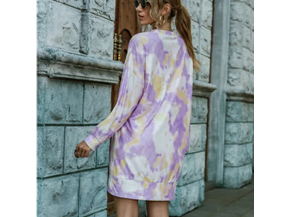 Back view of a model wearing a purple and yellow tie-dye long sleeve sweater dress.