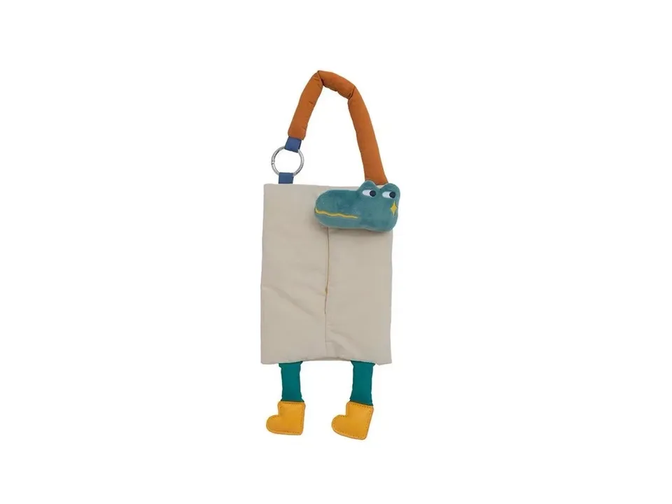 Beige crocodile plush tissue holder with dangling legs.