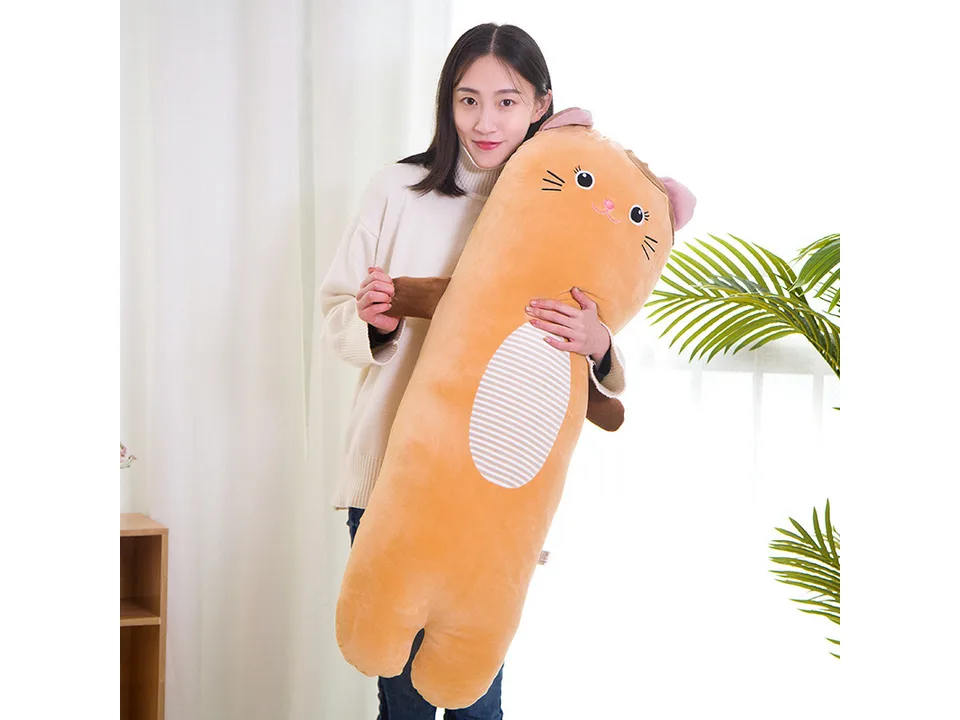 A woman holding a long, orange cat-shaped plush pillow.