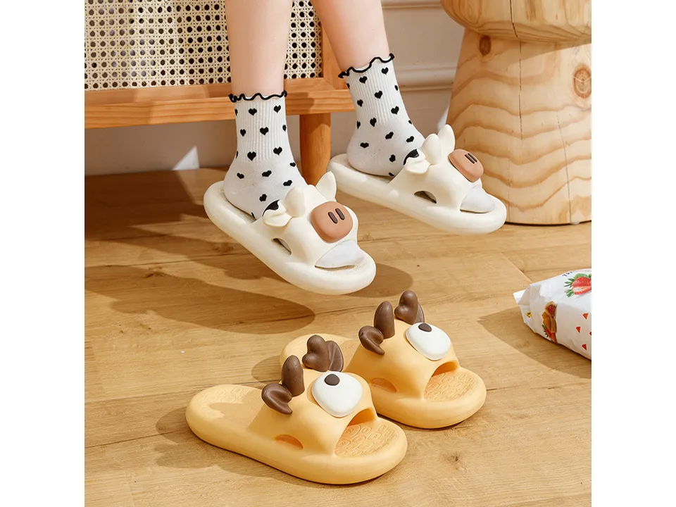 A person wearing white cow-themed slippers with patterned socks.