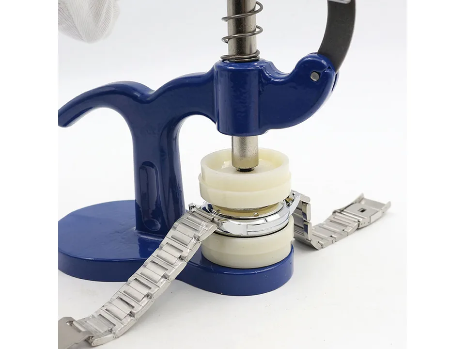 Watch case press tool being used to close a metal wristwatch.