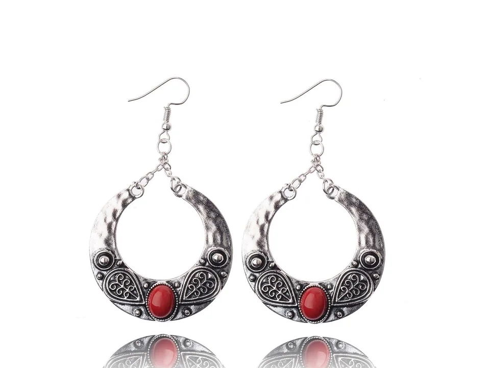 A pair of bohemian crescent-shaped earrings with red resin inlay.