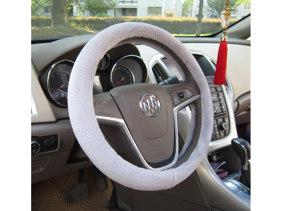 Grey plush steering wheel cover installed on a car steering wheel.