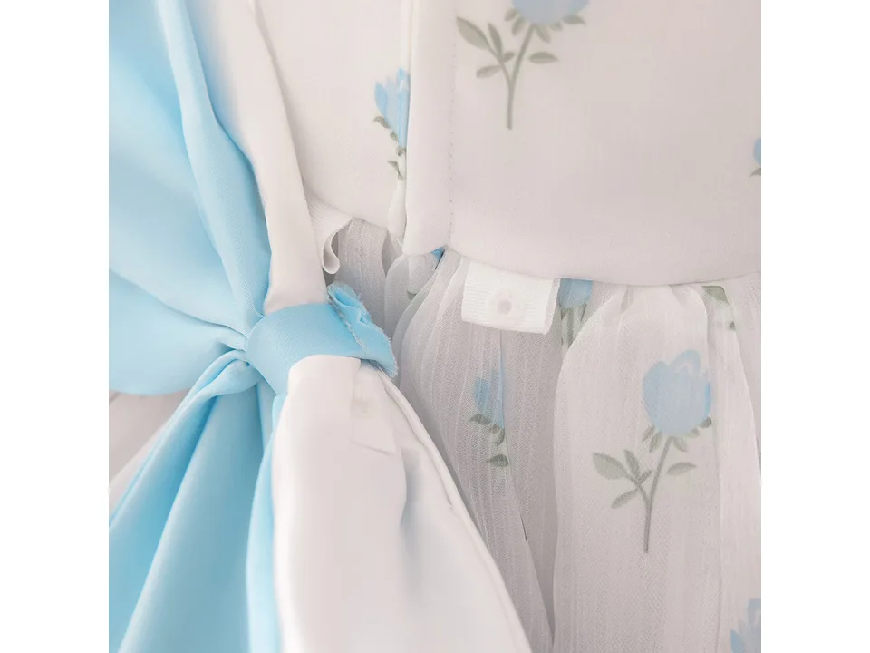 Close-up of the back of the dress showing the blue bow and snap fastener detail.