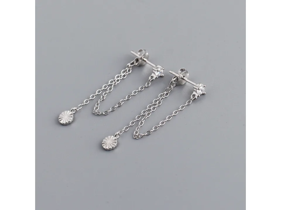 A pair of silver chain earrings with a small crystal stud and a textured round charm.