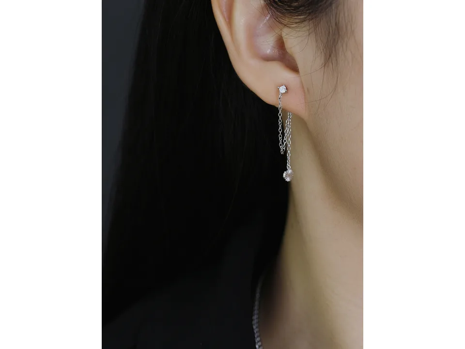 A close-up of a person wearing the silver chain earring.