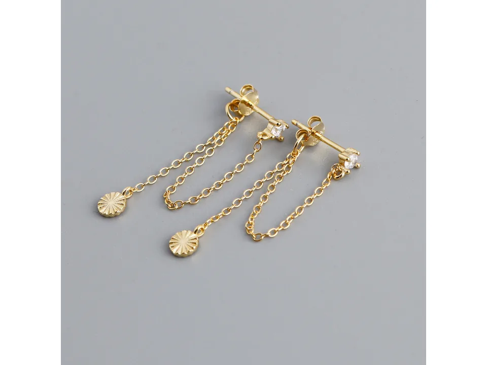 A pair of gold chain earrings with a small crystal stud and a textured round charm.