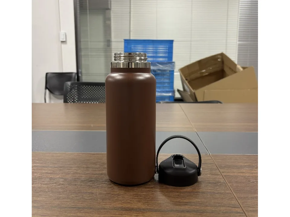 Brown water bottle with the lid removed, showing the stainless steel opening.