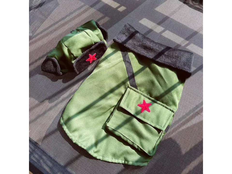 The green winter coat and matching trapper hat laid out together.
