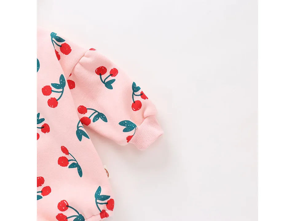 Close-up of the cherry print on the sleeve of the baby jumpsuit