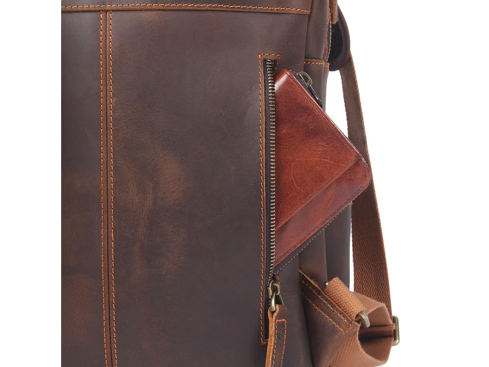 Close-up of a side zipper pocket on a brown leather backpack.