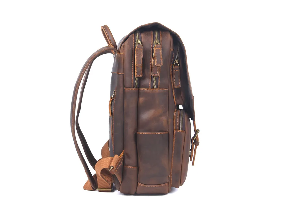 Side view of a brown leather backpack showing zippers and shoulder straps.