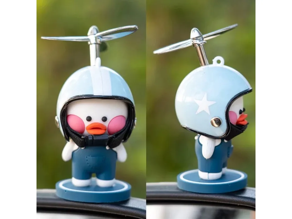 Close-up of a cartoon duck ornament wearing a yellow helmet with a propeller.