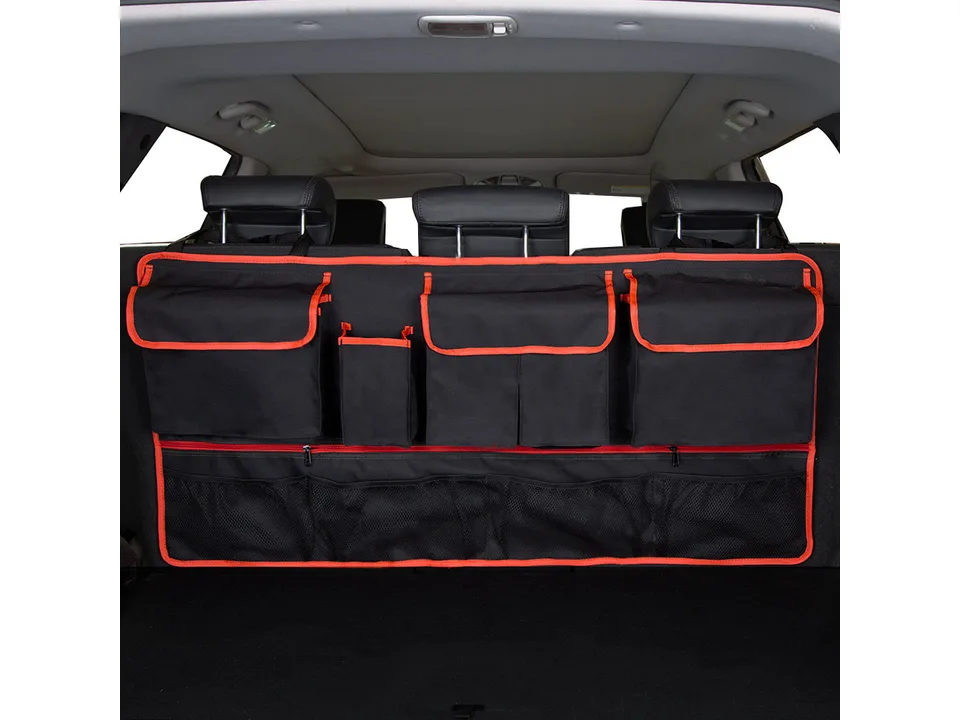 Car trunk organizer with red trim hanging on the back of rear seats.