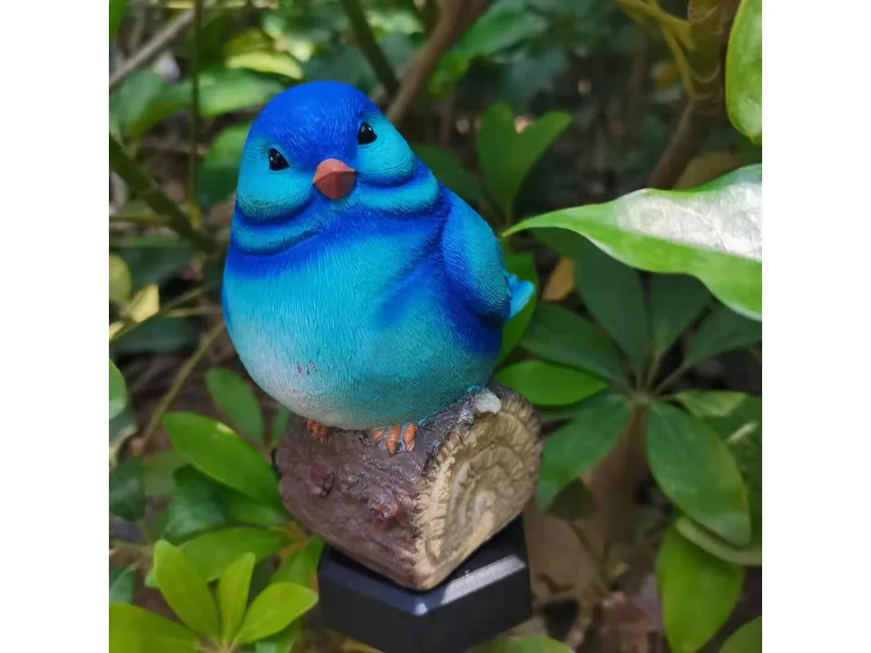 Close-up of a blue bird garden light ornament.