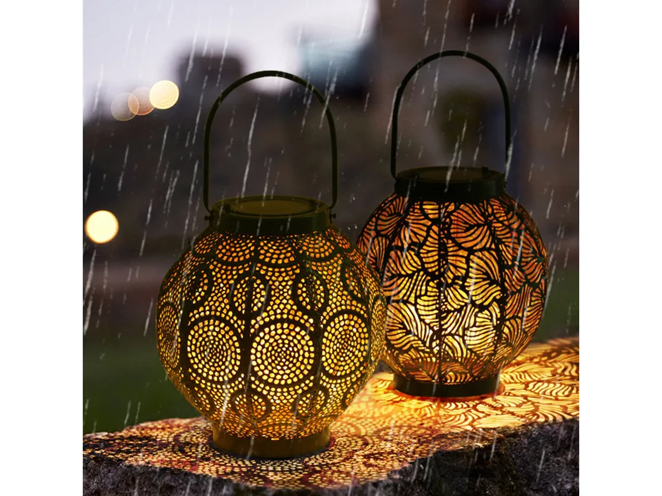 Two decorative metal lanterns glowing on a stone wall in the rain.