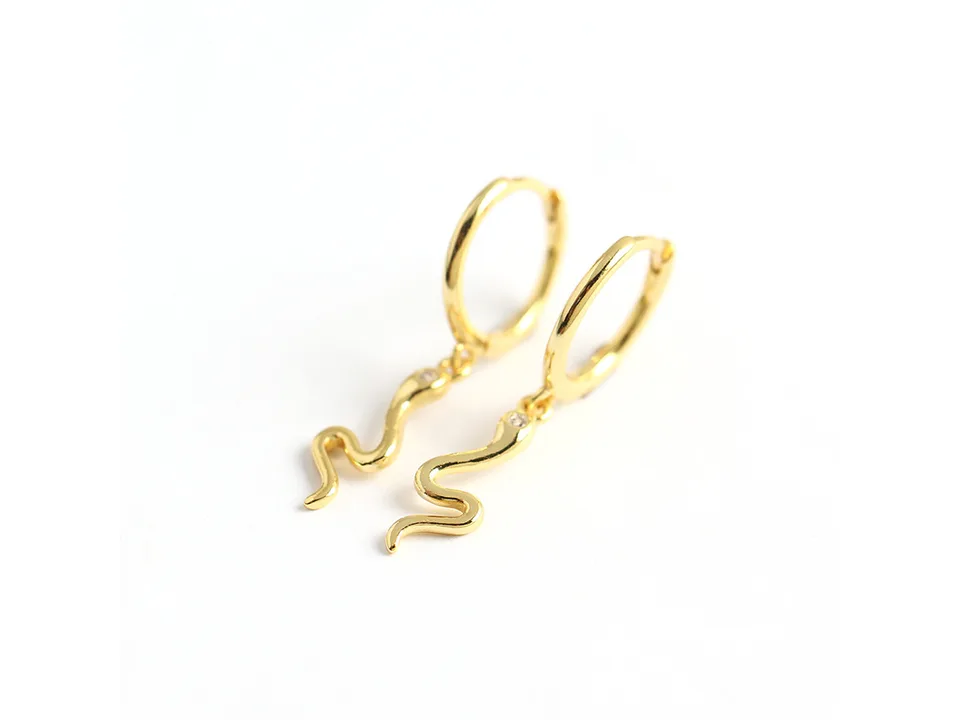 A pair of gold snake-shaped hoop earrings on a white background.