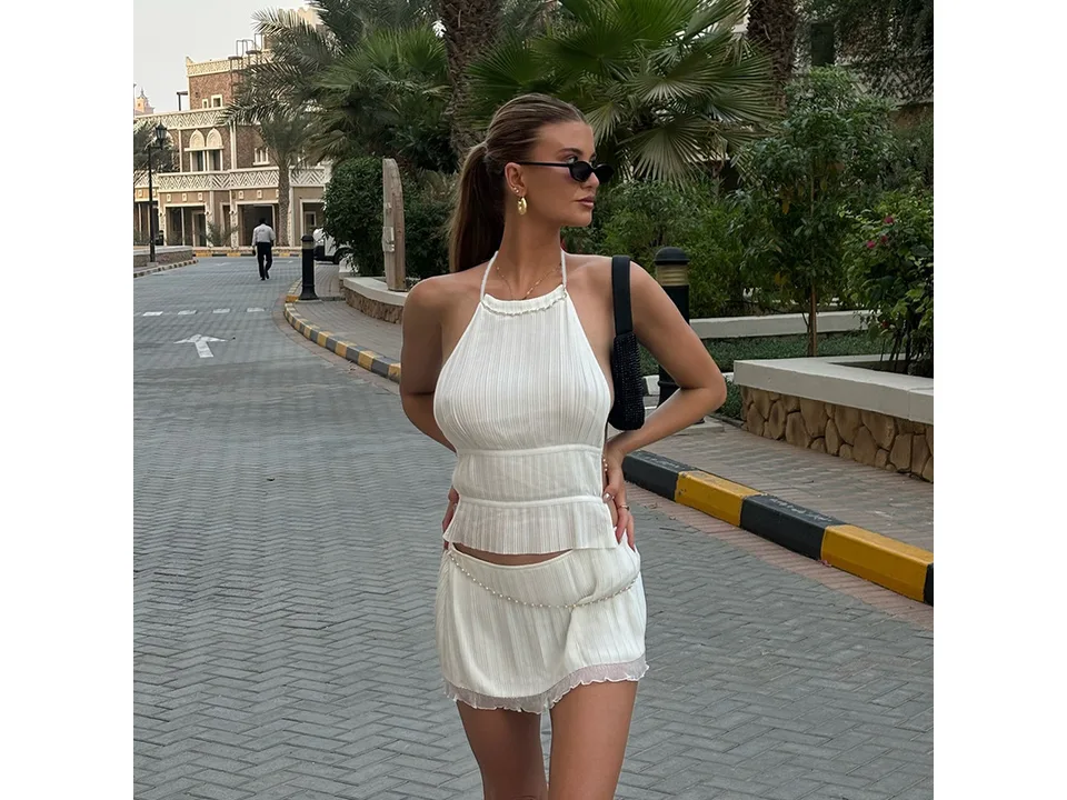 Woman wearing the white version of the halter top and mini skirt set
