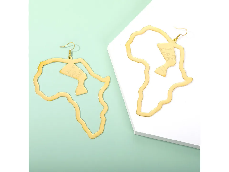 Gold-tone African map earrings with Egyptian queen silhouette on a white and green surface.