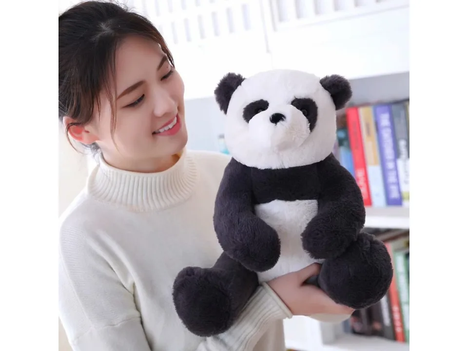 A person holding a plush panda toy.