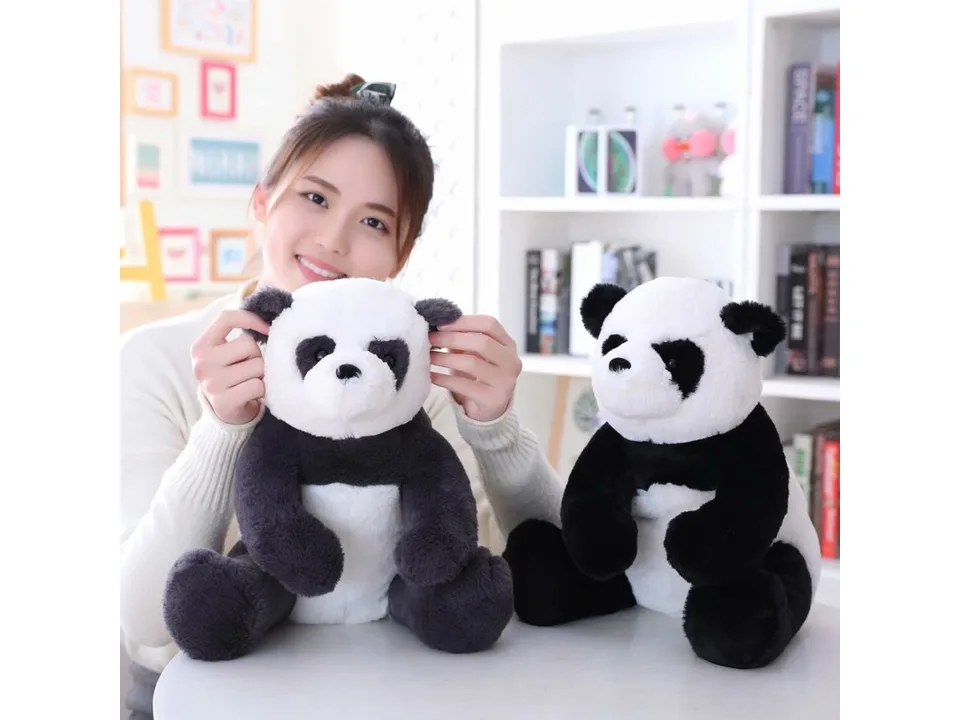 A person holding two plush panda toys.